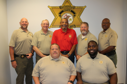 Deputy John Sambo, Chief Deputy Dennis Nichols, Coroner Calvin Dye Sr., Deputy Tom Boyd, Deputy James Nichols. Seated are Deputy John Peery and Deputy Damian Young Deputy John Sambo, Chief Deputy Dennis Nichols, Coroner Calvin Dye Sr., Deputy Tom Boyd, Deputy James Nichols. Seated are Deputy John Peery and Deputy Damian Young